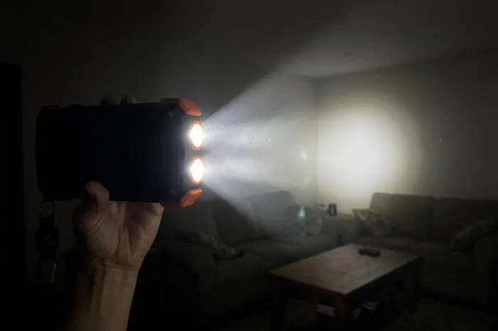 The power bank's twin LED flashlight lighting up a dark living room during a night-time outage